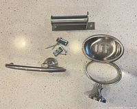 All three bathroom accessories with mounting hardware on countertop