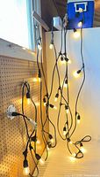 String lights hung and illuminated on pegboard wall