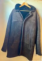 Front view of dark brown suede coat on hanger