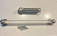Towel bar, toilet paper holder and mounting screws on countertop