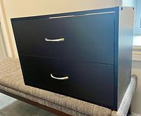 Front view of dark brown two-drawer dresser with metal pulls