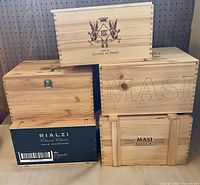 Five stacked wooden wine boxes showing branding on fronts