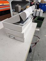 Stack of three white ADT touchscreen boxes, top box open showing contents