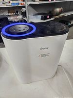 Front and top view of white Aroeve air purifier showing branding and top grille
