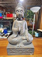 Front view of entire ceramic Buddha statue on base