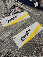Two sealed boxes of Energizer Industrial D12 batteries on wire cart