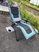 Full view of folding lounger chair set up outdoors with cup holder