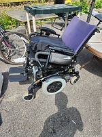 Full side view of Invacare power wheelchair showing overall design, tires, and seat