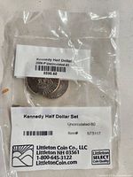 Front of sealed bag showing labels and one coin reverse