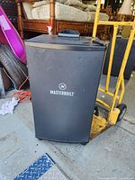 Front view of Masterbuilt smoker showing logo, control panel and overall appearance