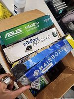 Box containing Asus motherboard box, EVGA graphics card box, generic mainboard box, visible RAM packs and Intel processor pack