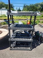 Full view of black plastic 4-tier shelving unit