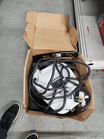 Box containing Siemens wall-mount EV charger, power cord, and cable