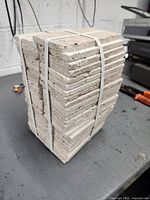 Full view of strapped stack of tiles standing upright