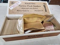 Open Martino cigar box filled with glassine envelopes of stamps