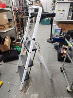 Full view of white 3-step ladder standing open