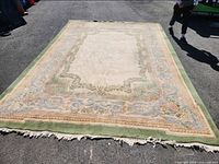 Full view of the wool area rug laid flat showing overall design and fringe
