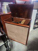 Full view of cabinet with lid open showing speaker grille