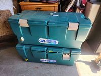 Two stacked green plastic storage totes showing exterior and size