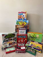 Stacked view of all boxed games showing titles Pie Face!, Mouse Trap, Harry Potter and others