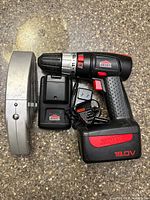 Drill with battery, charger base, AC adapter, handheld vacuum side view