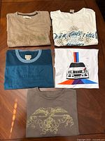 All five folded t-shirts displayed on table