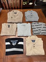 All six folded sweaters displayed on table