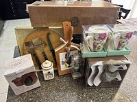 All items grouped on countertop showing boxes, boards, mugs, cups, jar, ornament
