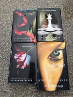 Top view of four Stephenie Meyer books showing covers: Eclipse, Breaking Dawn, New Moon, The Host