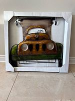 Full view of metal car wall art in packaging