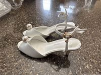 Side view of both sandals showing pearl toe detail, ankle straps and kitten heels