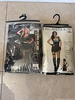 Front view of both packaged costumes on hangers