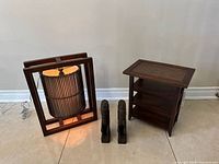 Group shot of lamp, shelf unit, and two carved figures