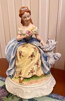 Front view of figurine showing lady, dog, colours and details