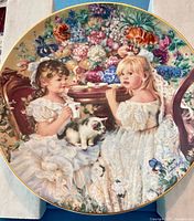 Front view of decorative plate with floral tea-party scene