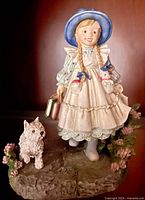Girl figurine front view showing attire, dog, and base details