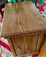 Angled view of cabinet showing front door, handle and side magazine rack profile