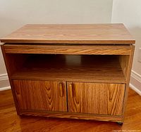 Front view showing swivel top, open shelf, two-door cabinet, casters