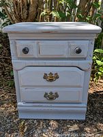 Front view of painted wood nightstand showing drawers and hardware