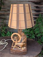 Full view of carved cedar lamp with shade and cord visible