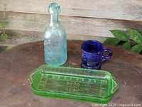 Aqua bottle, cobalt mug, green celery dish grouped on table