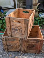 Stacked view of three wooden Party beverage crates outdoors