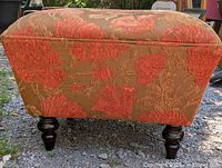 Full view of ottoman showing floral upholstery and legs
