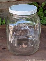 Front view of clear glass candy jar with white lid