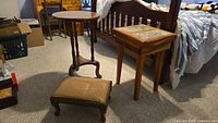 Group shot of all three pieces: square marble-top table, round pedestal table, footstool