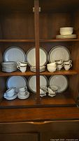 Cabinet shelves showing stacked Braemar plates, bowls, cups, saucers