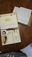 Closed box opened showing complete calligraphy set components and separate stationery pack lid.