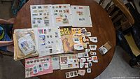 overview of entire collection spread on round table: album sheets, envelopes, album, box, loose stamps
