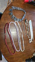 All seven necklaces and earrings laid out on tabletop