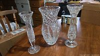 All three clear cut glass vases on table